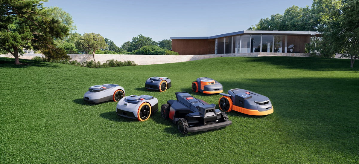 Segway Navimow robotic lawn mowers on a manicured lawn in front of a modern home