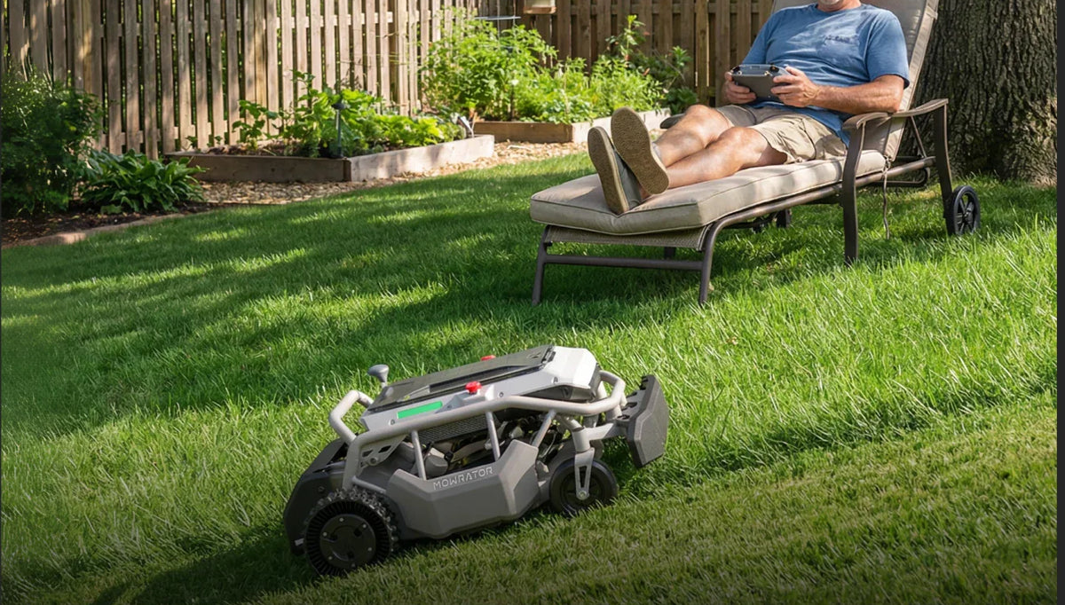 Operator running the Mowrator S1 by remote control from a shaded patio