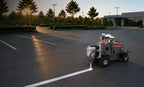 FJD PaintMaster Parking striping a new line in a parking lot at dusk