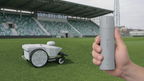 FJD FRX robotic mower in a stadium with the V4e handheld marker