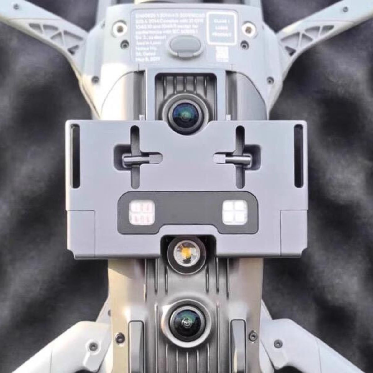 Air drop system mounted under a DJI Matrice 4 series drone, showing hooks and strobe lights