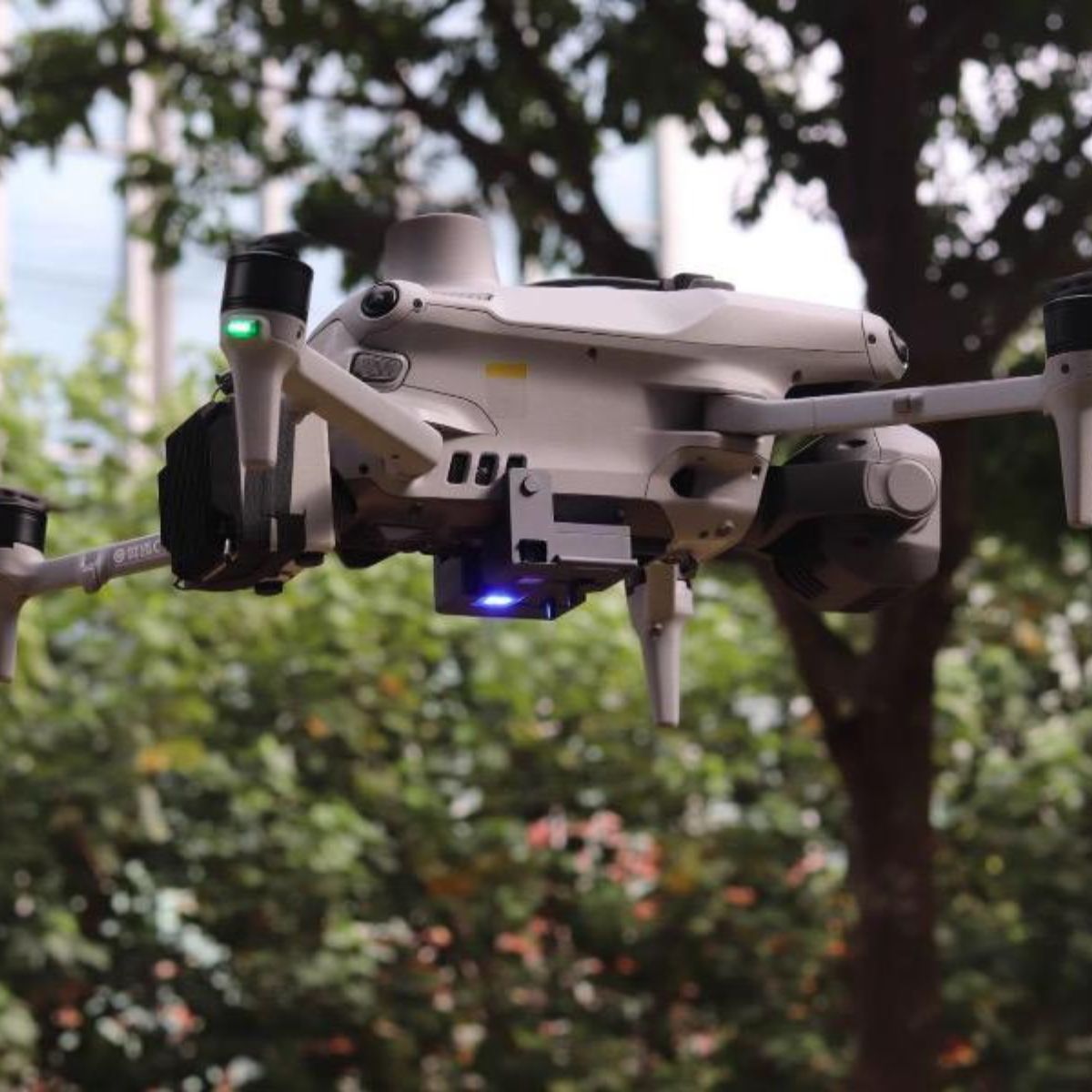 DJI Matrice 4 series drone in flight with the air drop system strobe lit