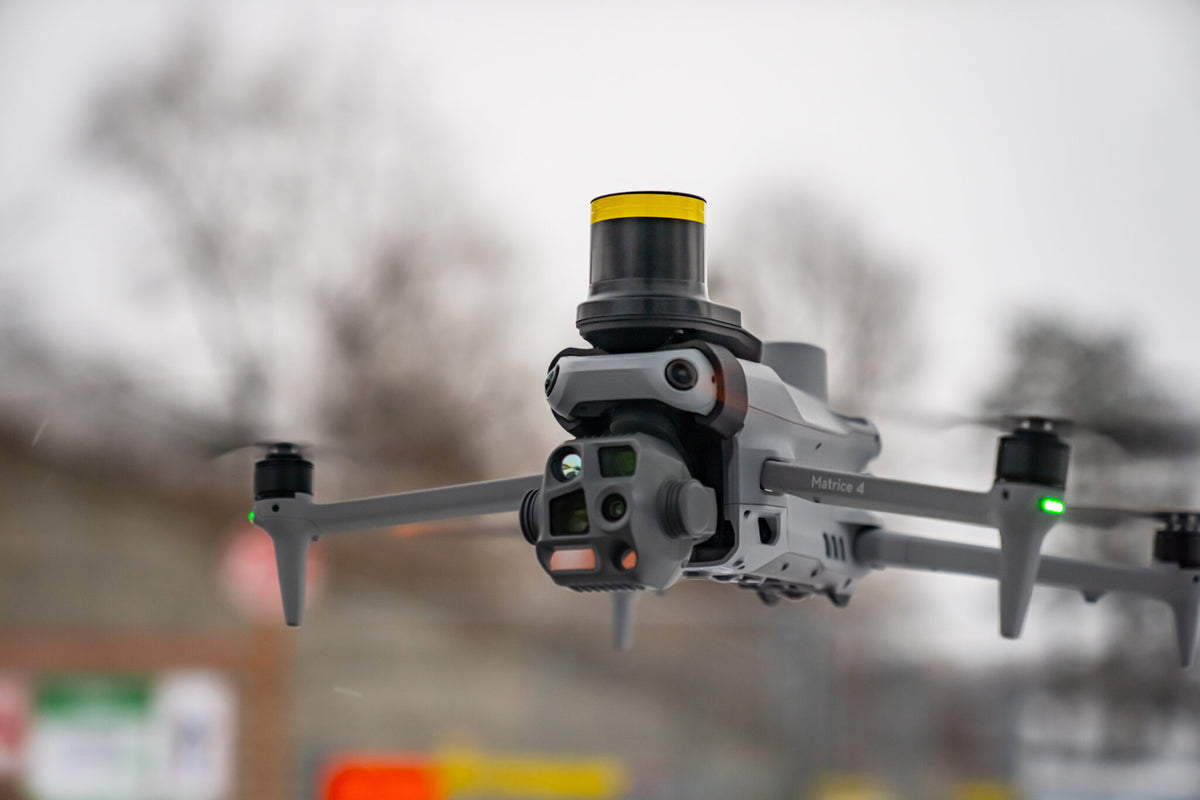 DJI Matrice 4 Series drone in flight with the AVSS PRS-M4S parachute recovery system on top