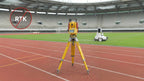 Total station on a running track guiding the FJD PaintMaster Ultra inside a stadium