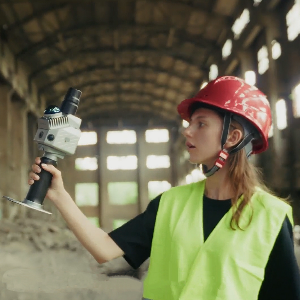 Surveyor holding the FJD Trion P2 handheld LiDAR scanner in an industrial building