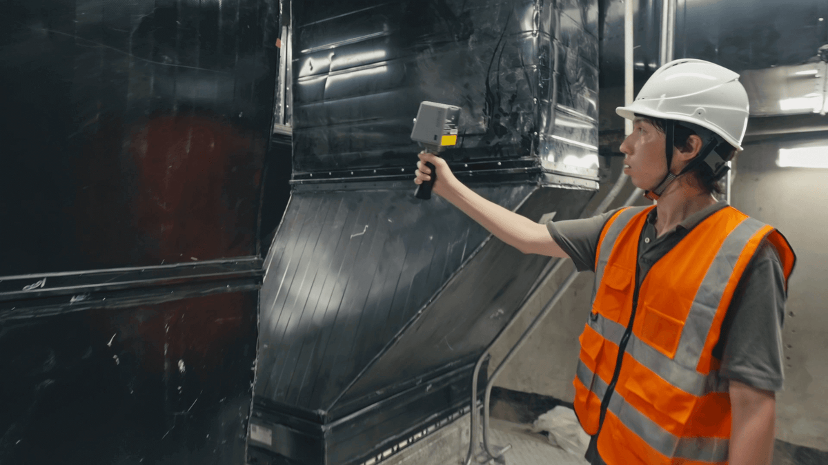 Technician in hard hat scanning ductwork with the FJD Trion P1
