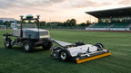 FJD Rough Ranger towing a grooming brush across synthetic turf at sunset